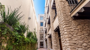 Un estrecho callejón entre edificios con fachadas de piedra y una puerta pequeña al final.