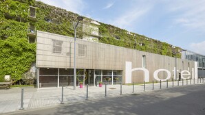 Un hotel moderno con techo plano, ventanas amplias y un llamativo letrero que dice 'hotel'.