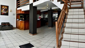 A spacious interior with a modern staircase, a kitchen area, and a seating area.