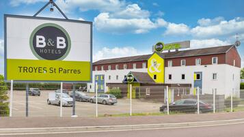 Een B&B hotelschbord met een parkeerplaats ervoor.