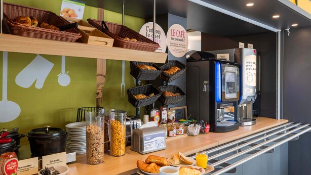 Een ontbijtbuffet met diverse soorten eten, manden en een koffieapparaat.