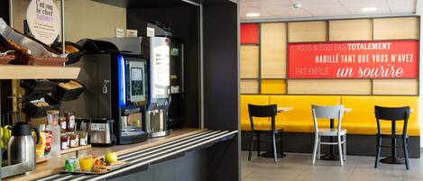 A breakfast bar with a coffee machine, toaster, and various breakfast items. There are two chairs and a yellow wall with a red sign.