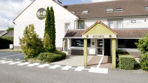 Un hotel tipo bed and breakfast con una entrada verde y un letrero que dice "ACCUEIL".