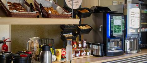 A breakfast buffet with various food items and a coffee machine.