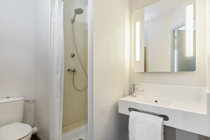 Une salle de bain avec des toilettes, une douche et un lavabo.