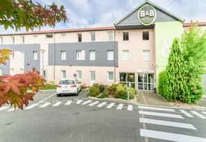 A hotel with a modern facade, a parking lot, and a clear entrance. - B&B HOTEL Belfort (Belfort)