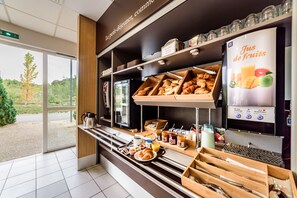 A breakfast buffet with pastries, fruits, and beverages. - B&B HOTEL Belfort (Belfort)