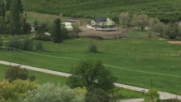 Een groot huis met een ruime tuin en uitzicht op het omliggende landschap.
