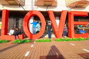 A building entrance with large red letters spelling "LOVE" and people sitting and standing in front. - Spa Inn Shirahama (Shirahama)