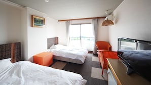 A hotel room with two beds, a desk, a chair, a television, and a window with curtains. - Spa Inn Shirahama (Shirahama)