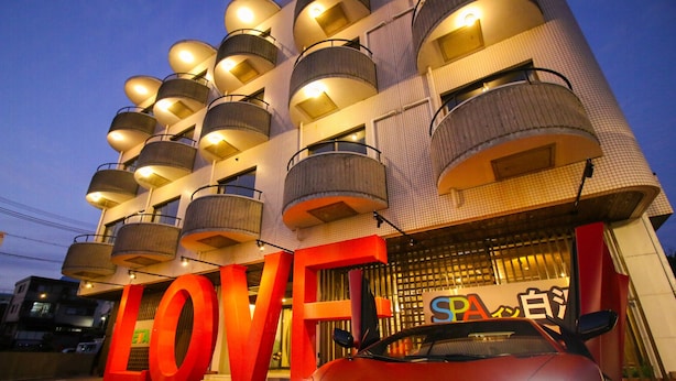 A building with a unique architectural design featuring circular balconies and a prominent 'LOVE' sign. - Spa Inn Shirahama (Shirahama)