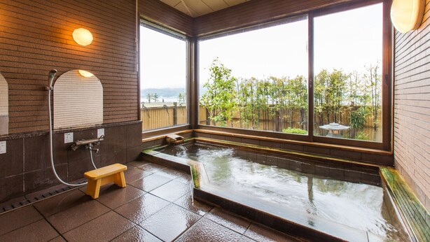 A modern bathroom with a large window, a small wooden bench, and a bathtub. - Jinpuso (Miyazu)