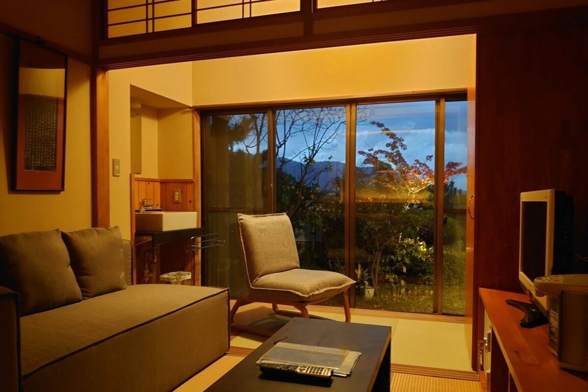 A modern living room with a sofa, a chair, a coffee table, and a TV.