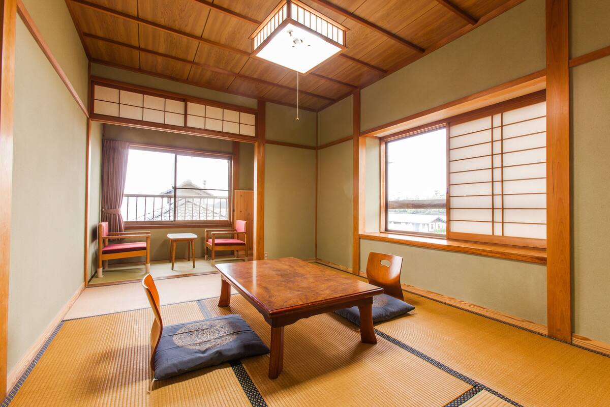 A traditional Japanese room with tatami flooring, a wooden table, and sliding shoji doors.
