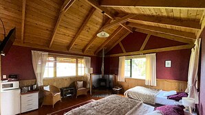 A cozy cabin with two beds, a desk, and a chair. - The River Lodge (Ohakune)