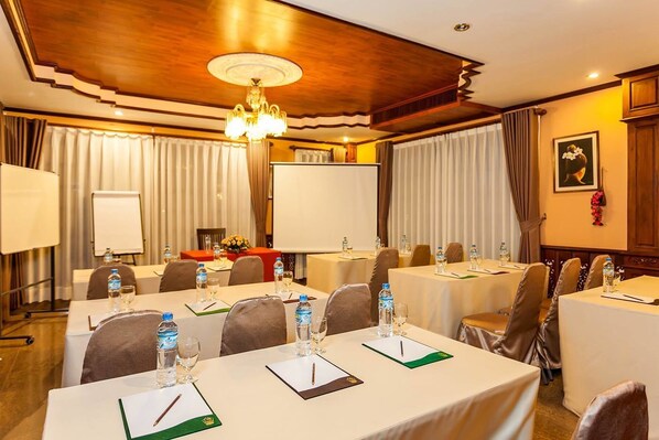 A conference room with tables set for meetings, equipped with water bottles, glasses, and notepads. - Chandara Boutique Hotel (Vientiane)