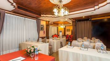 A conference room with tables set for meetings, equipped with water bottles and notepads.