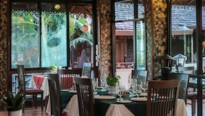 Un restaurante con muebles de madera, ventanas amplias y un ventilador de techo.