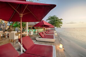 Am Strand, weißer Sandstrand, Liegestühle, Sonnenschirme
