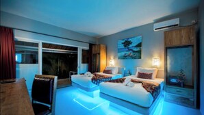 A modern hotel room with two beds, a dining area, and a large window with a view. - Bel Air Resort & Spa (Gili Air)