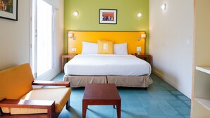 Ein Hotelzimmer mit einem Bett, einem Schreibtisch, einem Stuhl und einem Fenster.