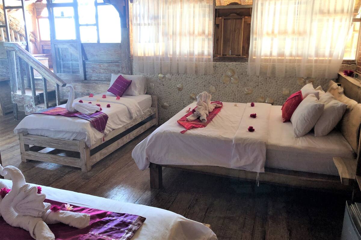 Una habitación con dos camas, cada una con una toalla con forma de cisne y flores rosas.
