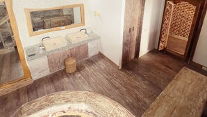 Un baño rústico con tocador de madera, un espejo y un ventilador de techo.