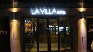 The exterior of La Villa Hotel with a glass entrance and illuminated signage. - Lavilla Hotel (Seoul)