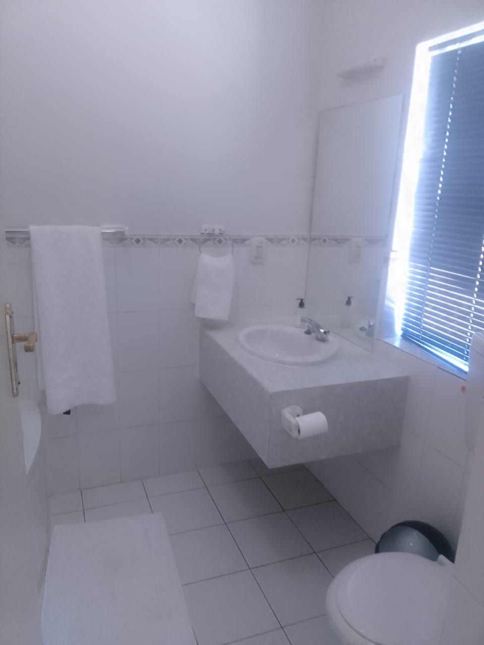 A bathroom with a sink, mirror, and toilet.