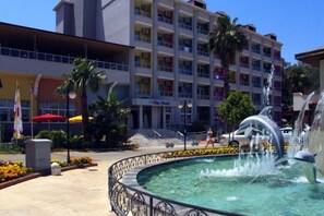 Una piscina al aire libre, sombrillas, sillones reclinables de piscina