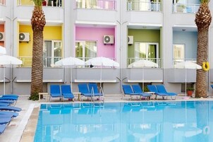 Una piscina al aire libre, sombrillas, sillones reclinables de piscina