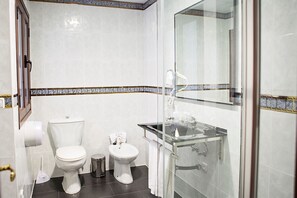 A bathroom with a toilet, bidet, and a glass shower enclosure. - Casa de los Faroles (Córdoba)