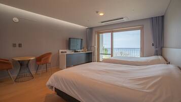 Quarto de hotel moderno com duas camas, uma escrivaninha e uma cadeira.