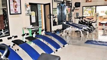 Un gimnasio con equipo de ejercicio, un espejo y un cartel en la pared.