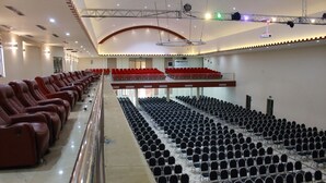 A large hall with rows of black chairs and red chairs on the upper level. - Eusbett Hotel (Sunyani)