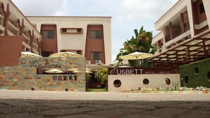 A modern hotel entrance with a sign for 'Eusbett Hotel Limited' and a 'Francisca Court' sign. - Eusbett Hotel (Sunyani)