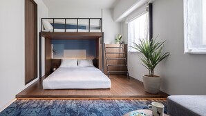 A compact hotel room with a bunk bed, a small desk, a potted plant, and a window with curtains. - Estinate Hotel Naha (Naha)