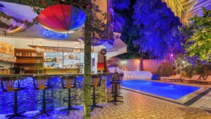 An indoor pool area with a bar and seating.