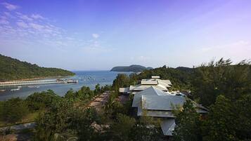 Uma área costeira com vista para o mar, uma ponte e um conjunto de edifícios com arquitetura tradicional.