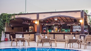 Zona de bar al aire libre con piscina, asientos y barra.