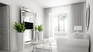 Un salon moderne avec un canapé blanc, une table basse et deux plantes en pot.