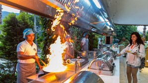 A buffet setup with a grill and food service area, surrounded by greenery. - Lâ€™ETOILE BEACH HOTEL - All inclusive (Marmaris)