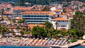 A coastal hotel with multiple floors, a beach area with umbrellas, and a view of the sea. - Lâ€™ETOILE BEACH HOTEL - All inclusive (Marmaris)