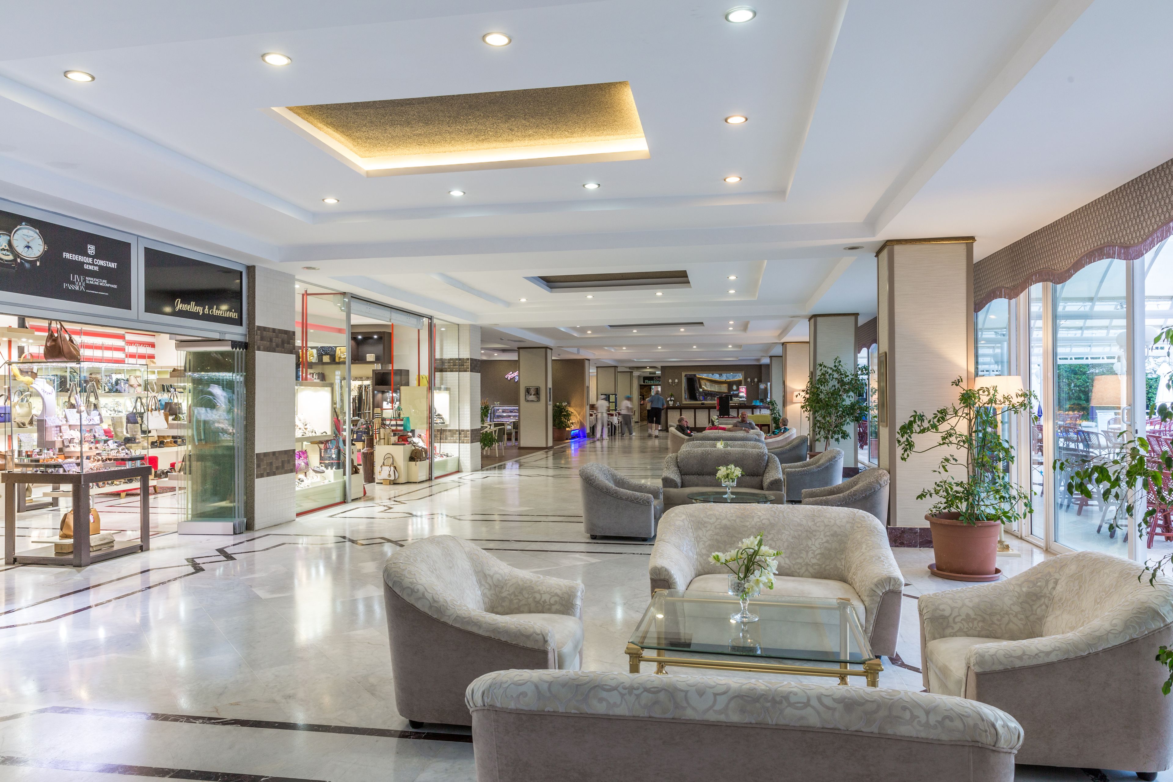 A spacious lobby with seating areas, a jewelry store, and large windows.