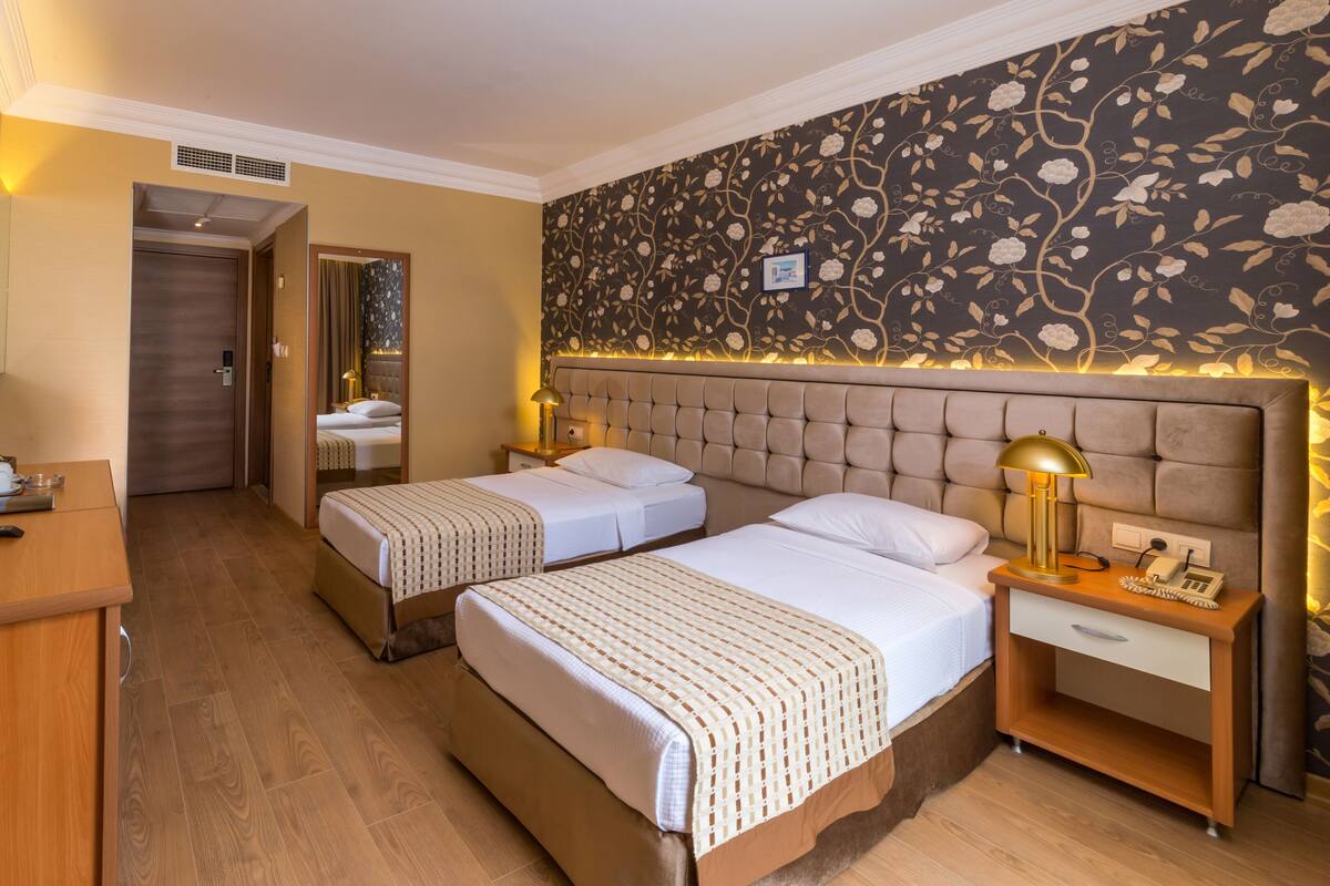 Une chambre d’hôtel avec deux lits, un bureau, une télévision et une salle de bain.