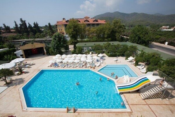 Alberca al aire libre, sombrillas en la alberca y camastros 