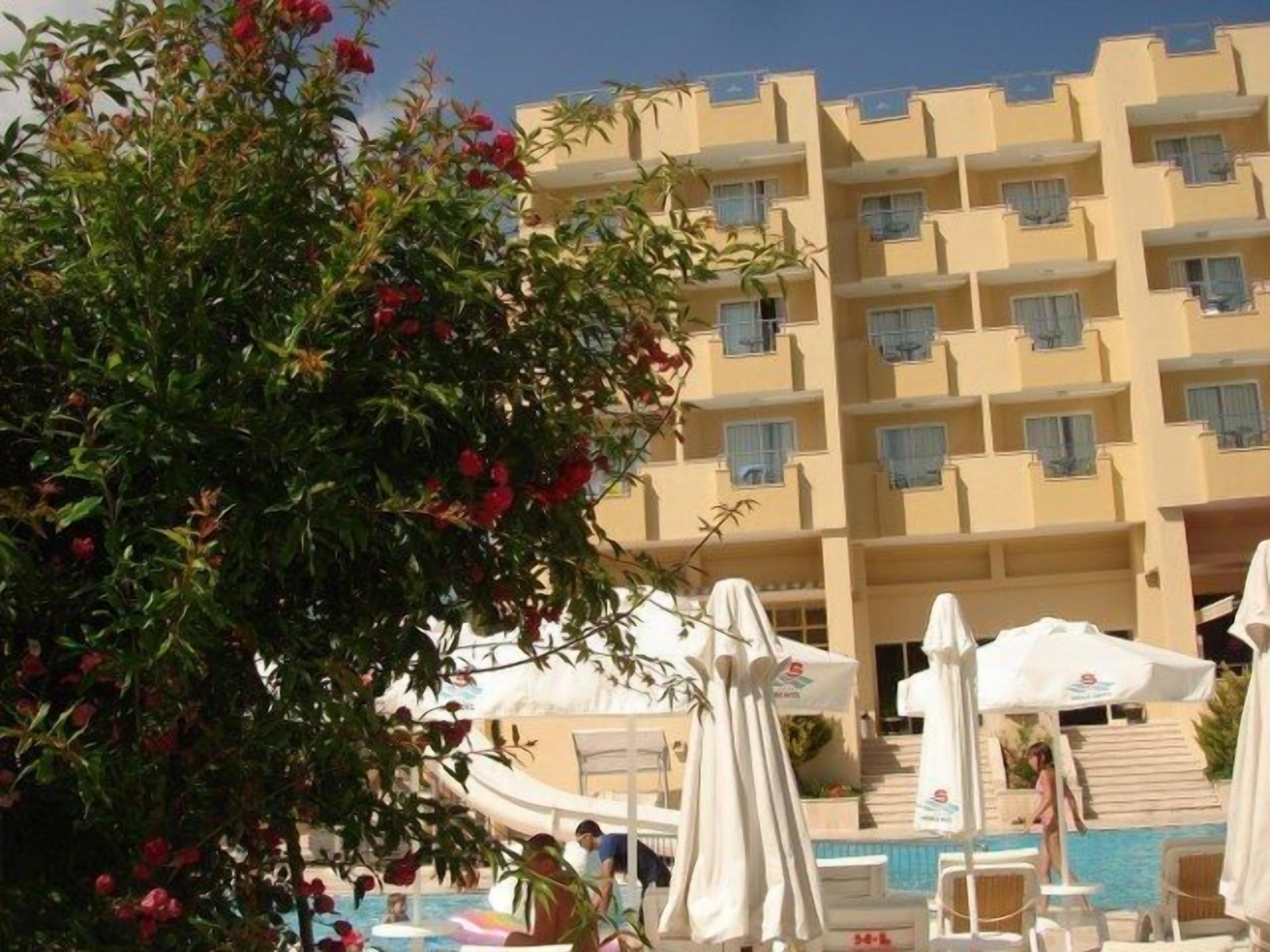 A hotel with a pool area, multiple balconies, and a building facade with uniform windows.