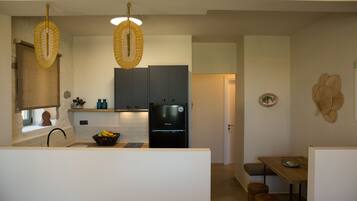 A modern kitchen with a refrigerator, sink, and wooden dining table.