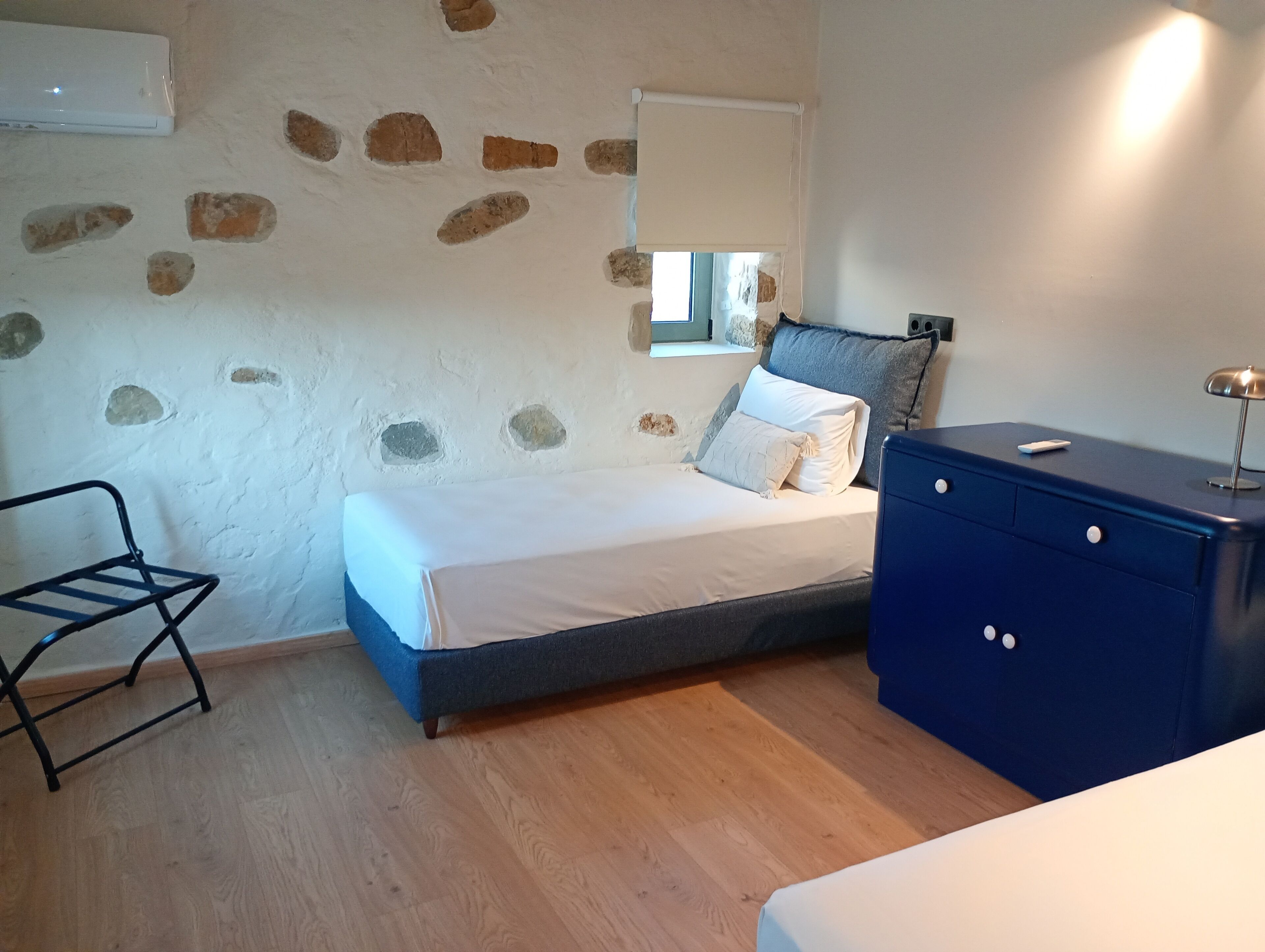 A bedroom with a bed, a dresser, a chair, and a window.
