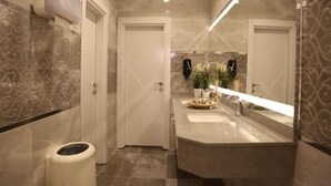 Un baño moderno con tocador, lavabo y espejo.
